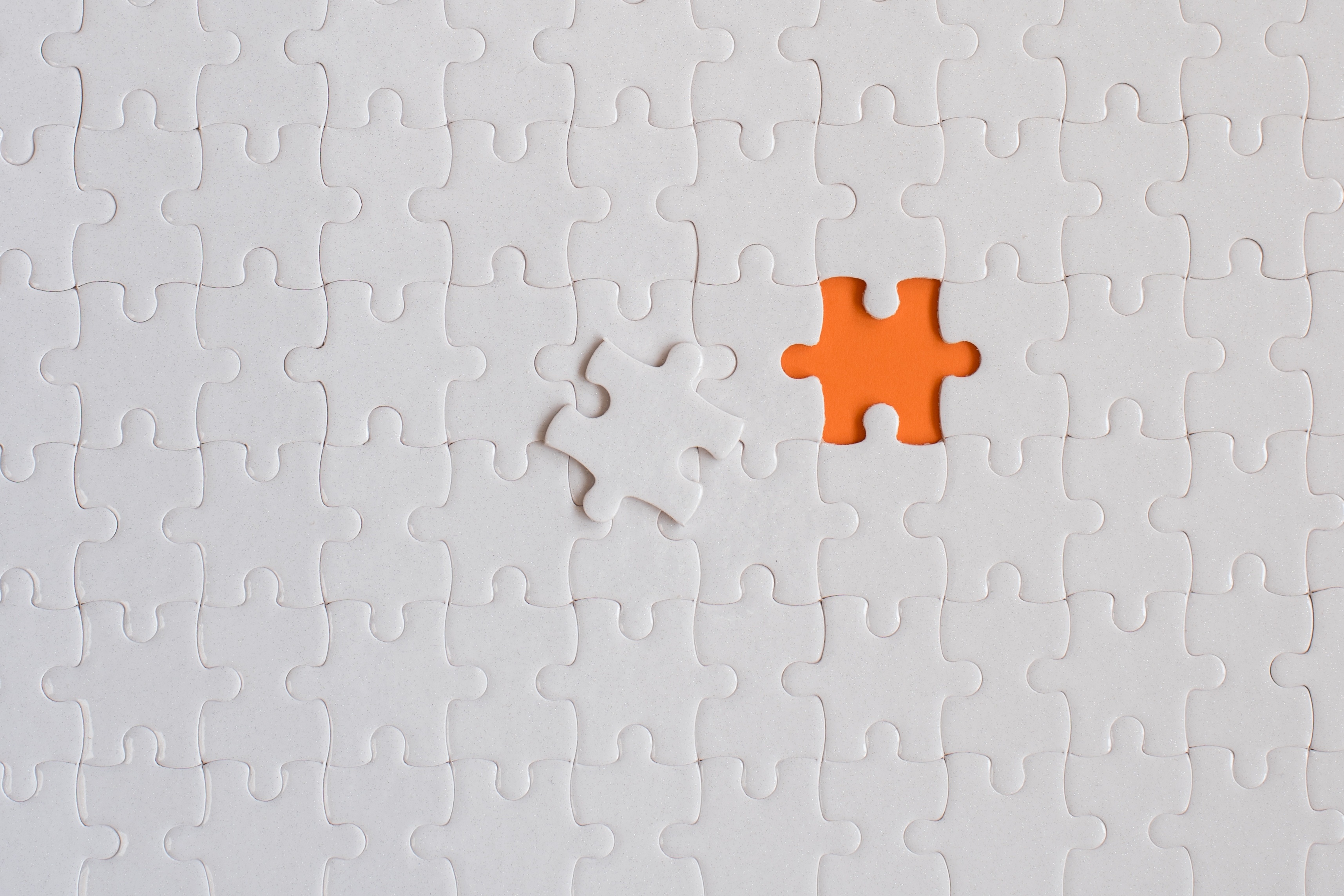 A white puzzle with one missing piece.''